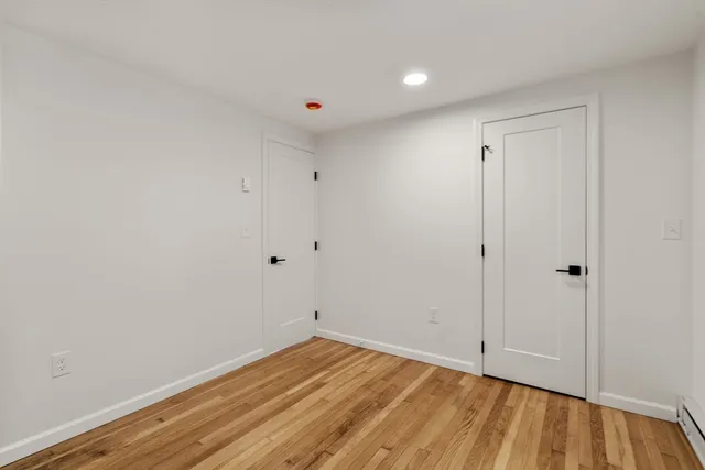 a view of a room with wooden floor and white walls
