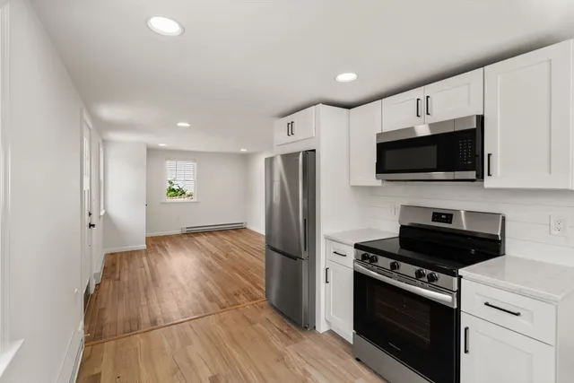 a kitchen with stainless steel appliances a refrigerator a stove top oven a sink and cabinets