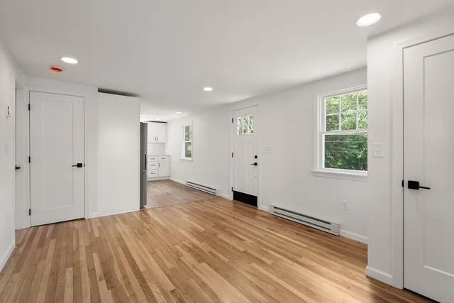 a view of a room with wooden floor and windows