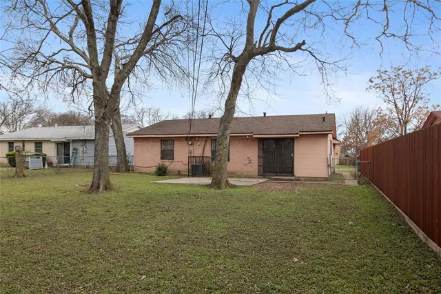 a front view of a house with a garden and trees