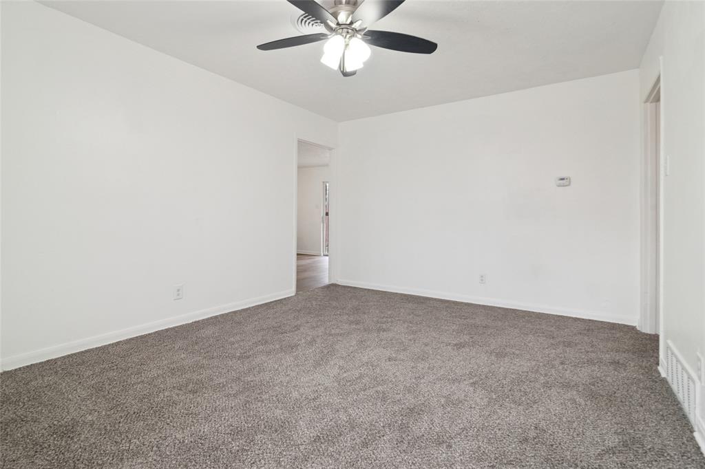 7840 Larchridge Drive Dallas, TX 75232 - Photo 4 of 16 an empty room with a window and a fan