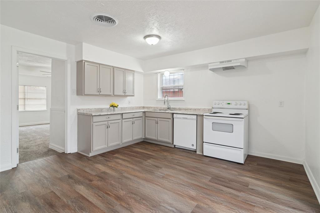7840 Larchridge Drive Dallas, TX 75232 - Photo 5 of 16 a kitchen with white cabinets sink and white appliances