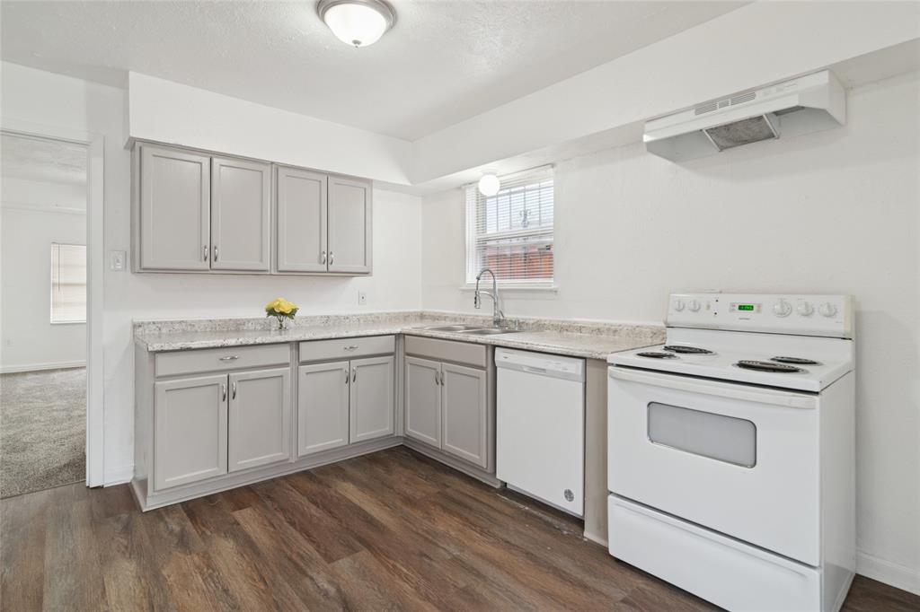 7840 Larchridge Drive Dallas, TX 75232 - Photo 6 of 16 a kitchen with granite countertop white cabinets and white appliances