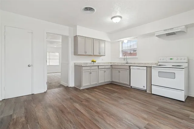 a kitchen with white cabinets stainless steel appliances and sink