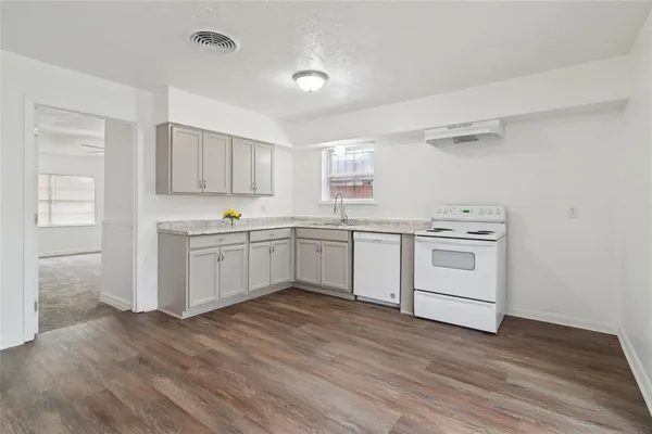 a kitchen with white cabinets sink and white appliances