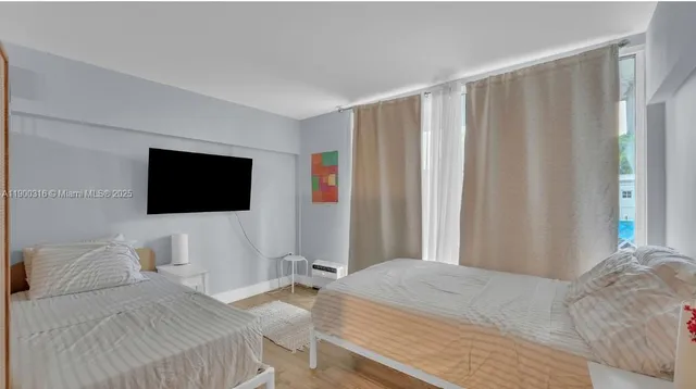 a bedroom with a bed and a flat screen tv