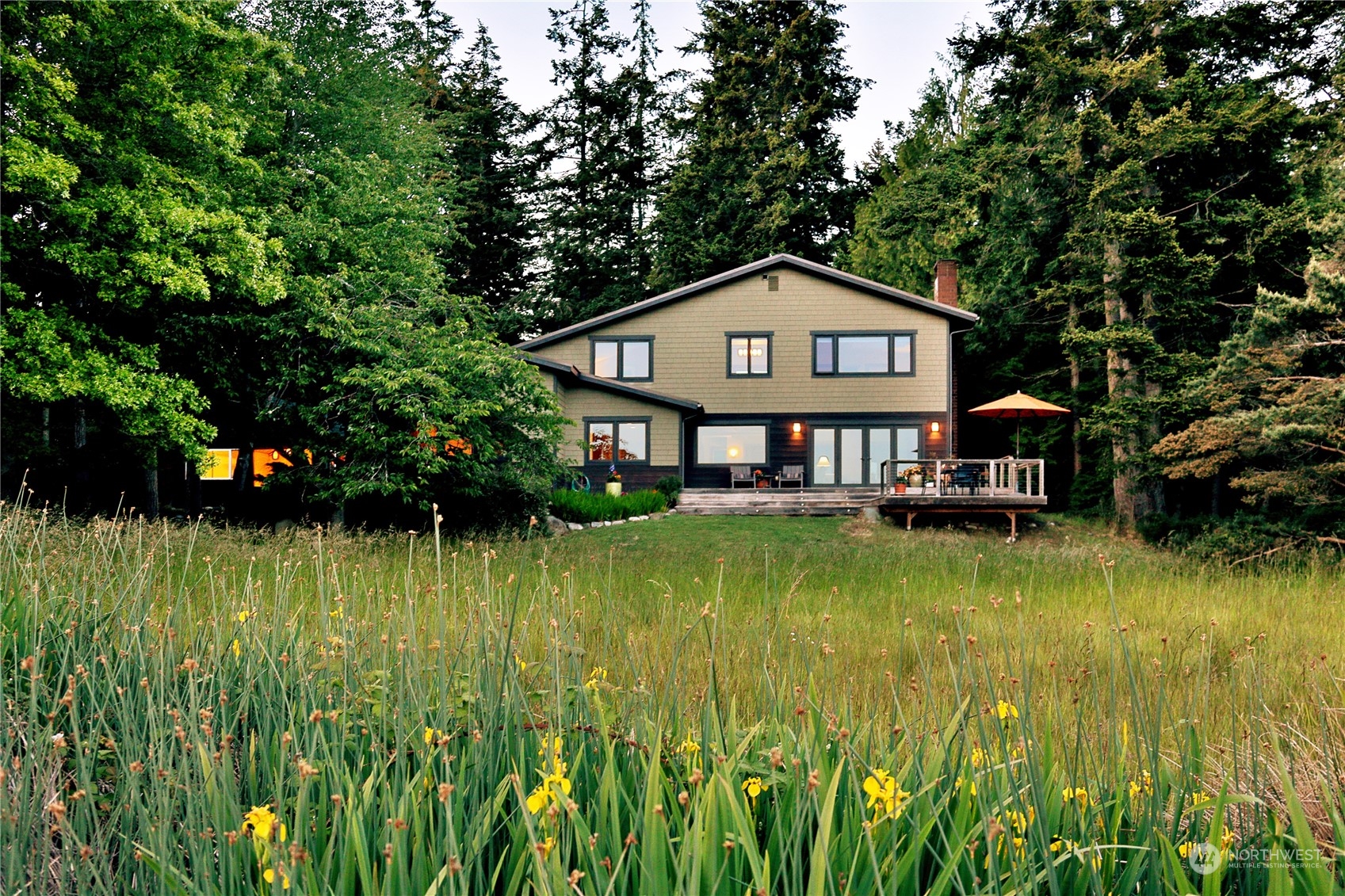 6567 Wahl Road Freeland, WA 98249 - Photo 1 of 40 a view of a house next to a big yard with plants and large trees