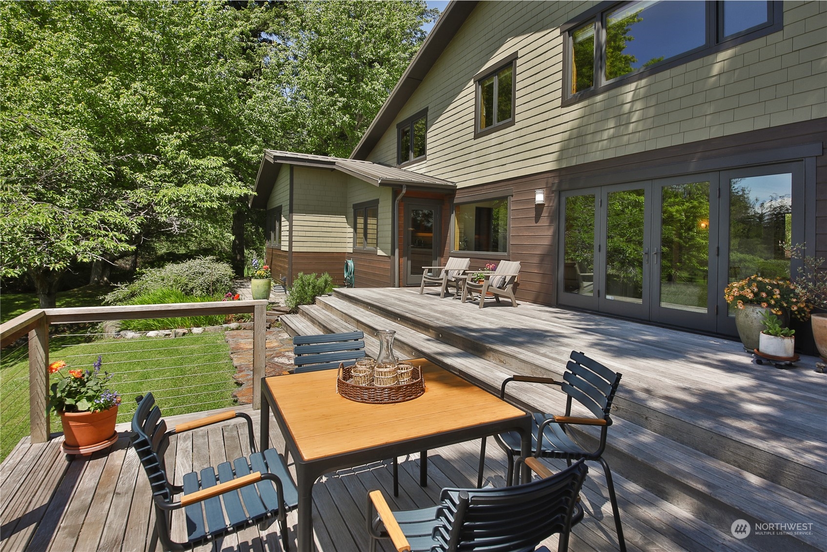 6567 Wahl Road Freeland, WA 98249 - Photo 12 of 40 a view of a patio with a dining table and chairs with wooden floor