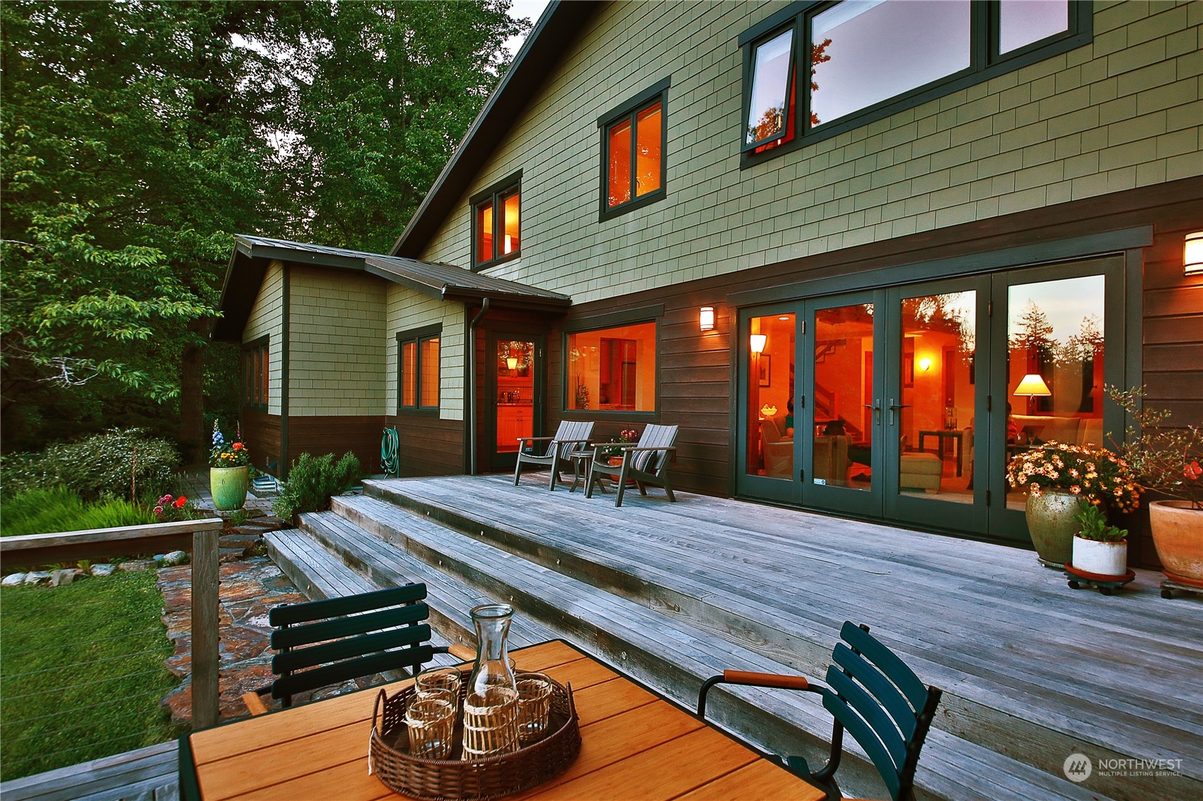 6567 Wahl Road Freeland, WA 98249 - Photo 29 of 40 a view of a patio with table and chairs potted plants with wooden floor and fence