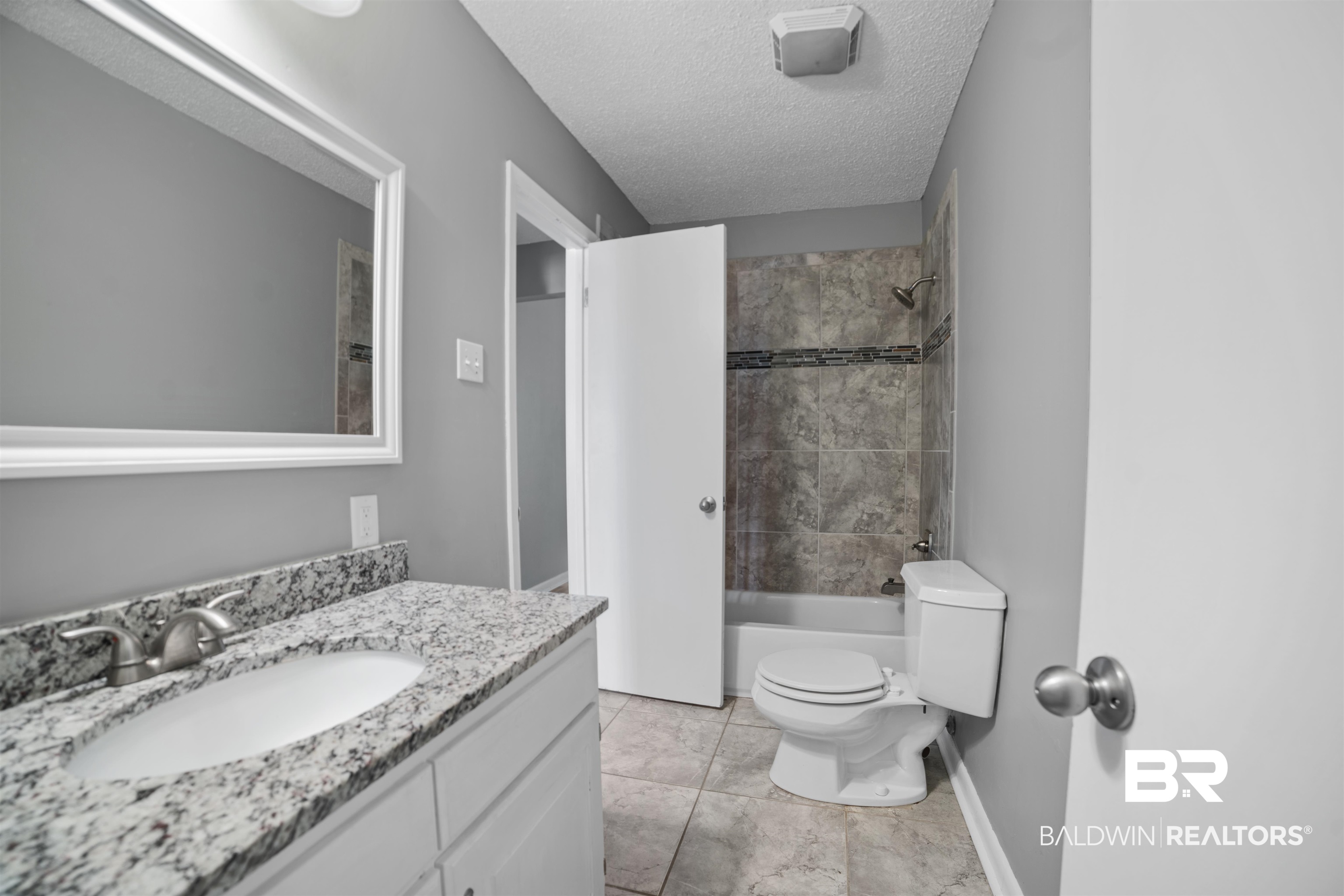 804 Regents Drive West Mobile, AL 36609 - Photo 24 of 35 Bathroom with a textured ceiling, vanity, washtub / shower combination, and tile patterned floors