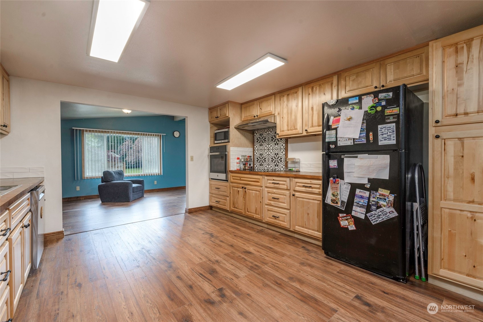18524 Ivan Street Southwest Rochester, WA 98579 - Photo 7 of 20 a kitchen with stainless steel appliances kitchen island wooden floors cabinets and counter space