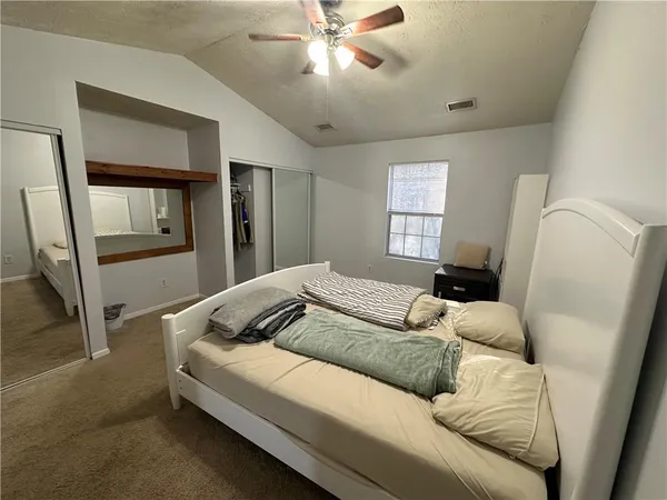 a bedroom with a bed and a large mirror
