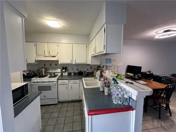 a view of a kitchen with refrigerator and white cabinets