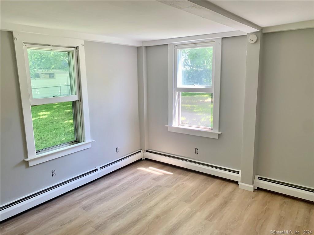 551 North Main Street, Unit 1R Naugatuck, CT 06770 - Photo 7 of 13 an empty room with wooden floor and windows