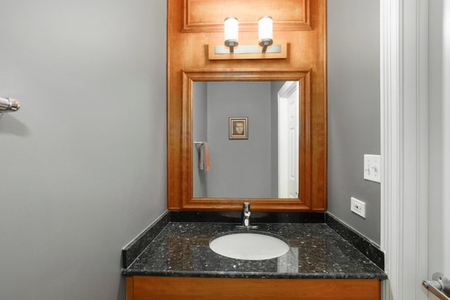 2651 West Rice Street Chicago, IL 60622 - Photo 12 of 20 a bathroom with a granite countertop sink and a mirror