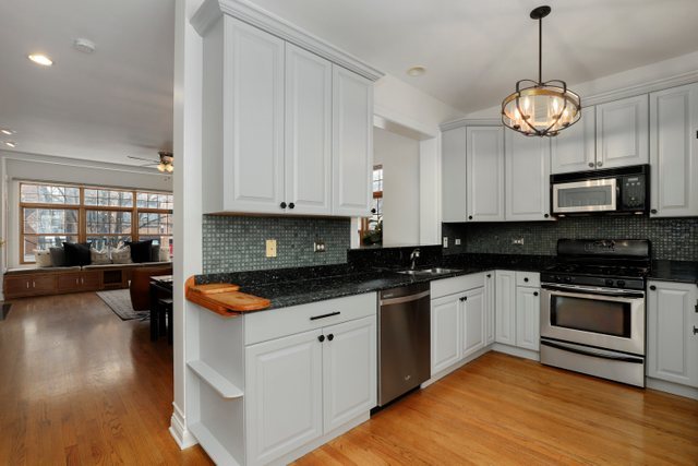 2651 West Rice Street Chicago, IL 60622 - Photo 6 of 20 a kitchen with stainless steel appliances granite countertop a stove and a wooden floors