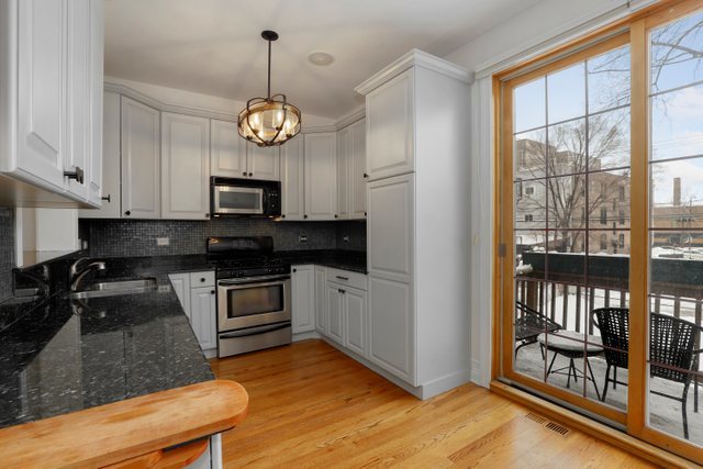 2651 West Rice Street Chicago, IL 60622 - Photo 7 of 20 a kitchen with granite countertop a stove a sink and a granite counter top