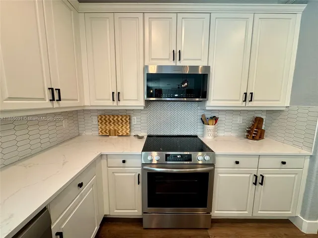 a kitchen with a stove and white cabinets
