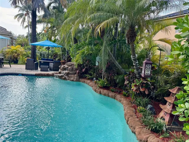 a view of a backyard with furniture and a garden