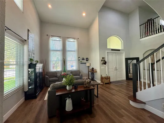a living room with stainless steel appliances kitchen island granite countertop a sink and a black cabinets