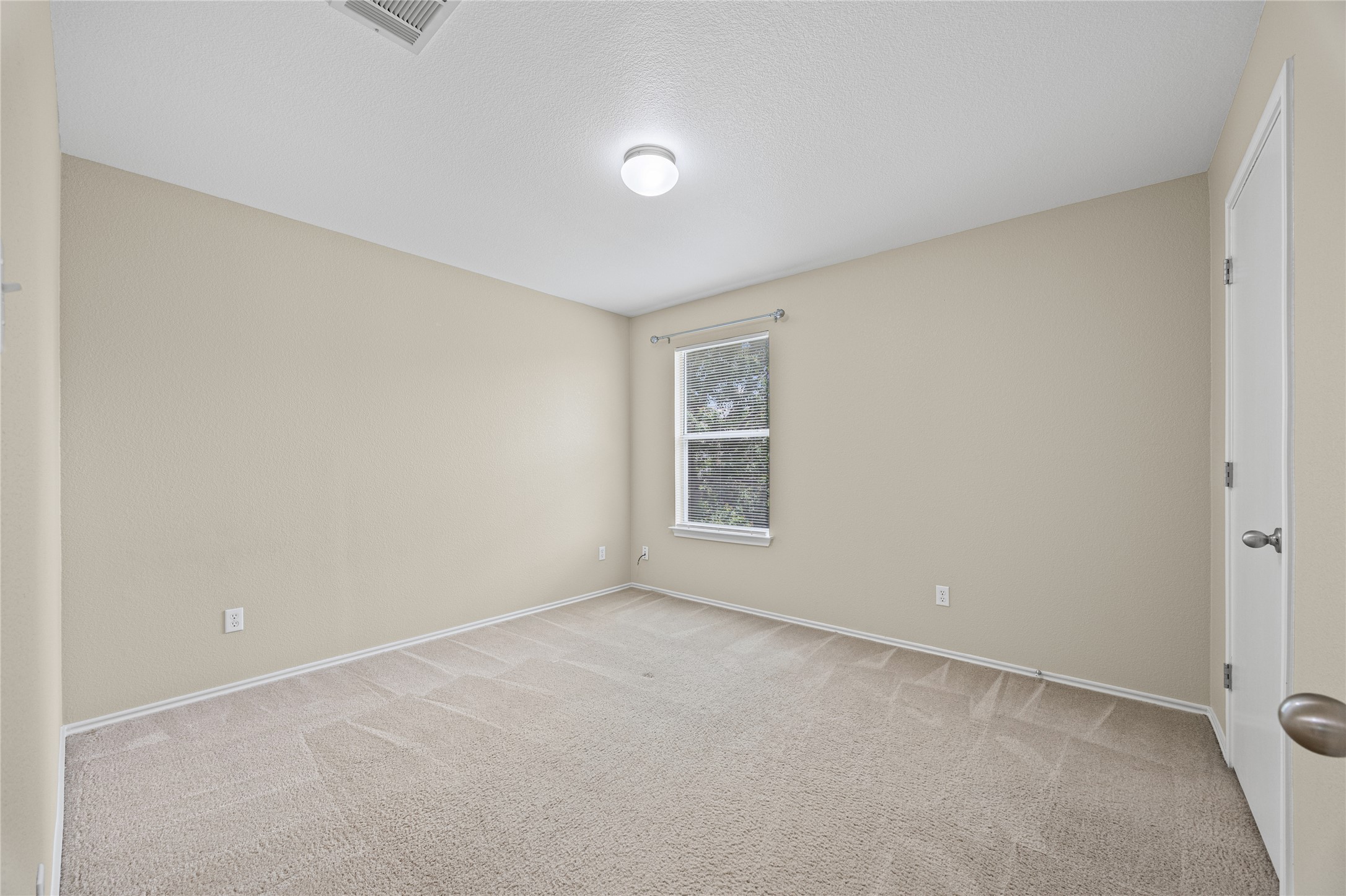 198 Black Forest Road Buda, TX 78610 - Photo 13 of 23 A well-lit bedroom provides a cozy retreat with soft carpeting and a window offering natural illumination.