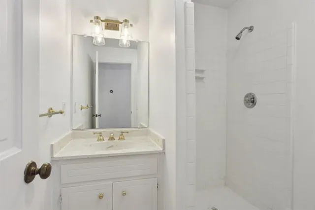 a view of empty room with wooden floor and kitchen