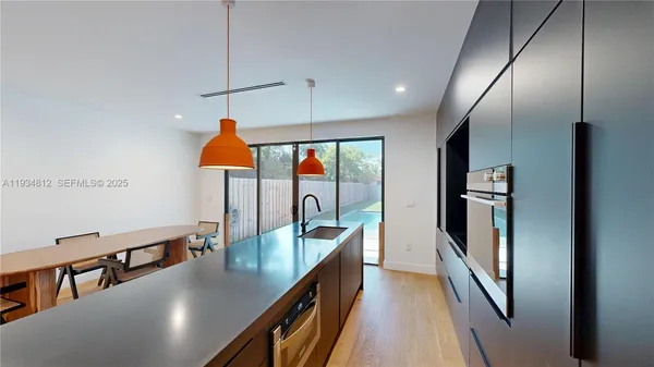 a kitchen with stainless steel appliances granite countertop a sink a stove and a refrigerator