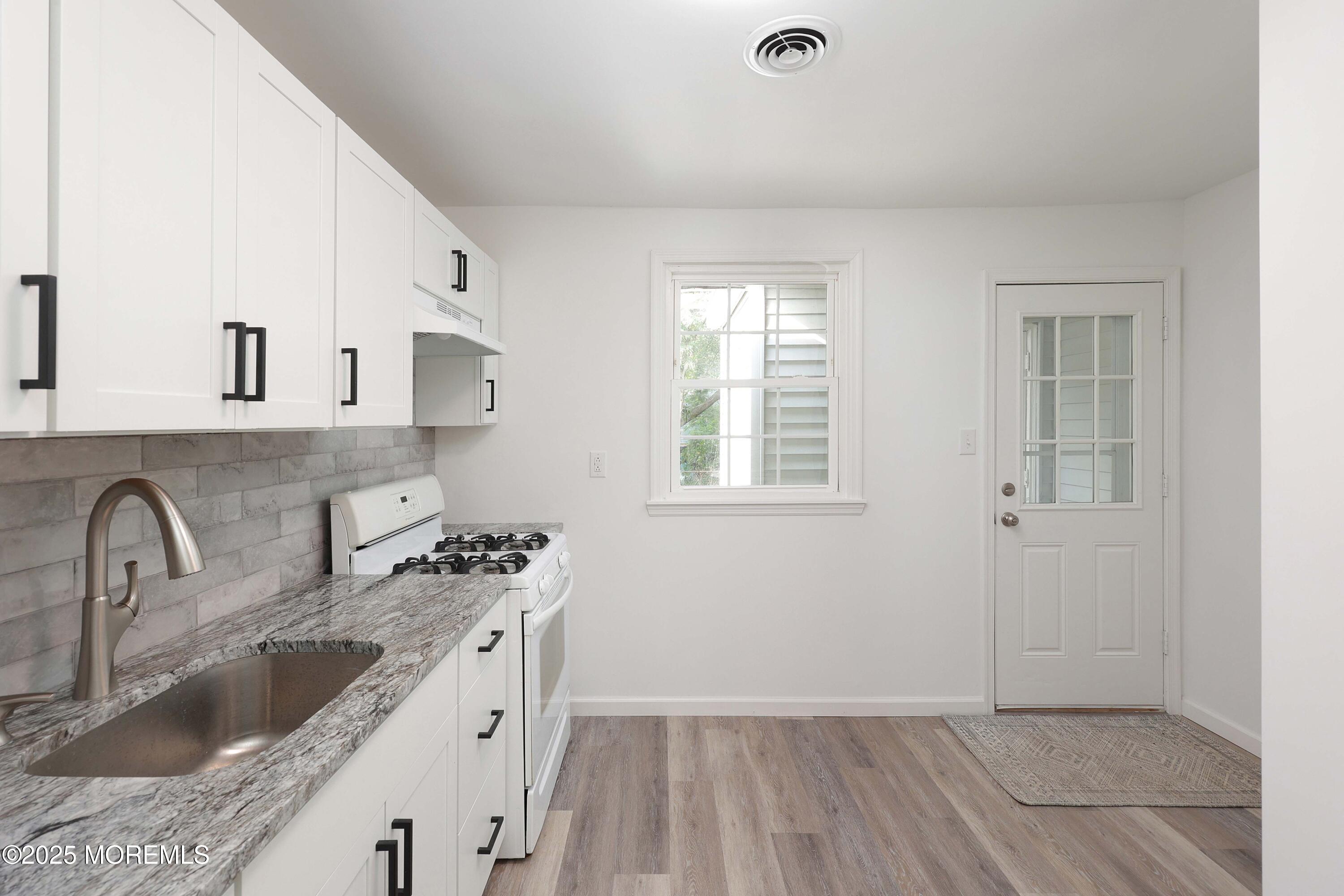914 Pemberton Browns Mills Road Pemberton, NJ 08068 - Photo 11 of 28 a kitchen with granite countertop a sink a stove and cabinets