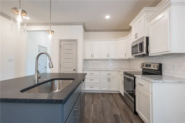 a kitchen with a sink stove and microwave