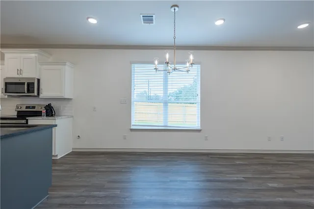 a view of a kitchen stove kitchen island with wooden floor and stainless steel appliances