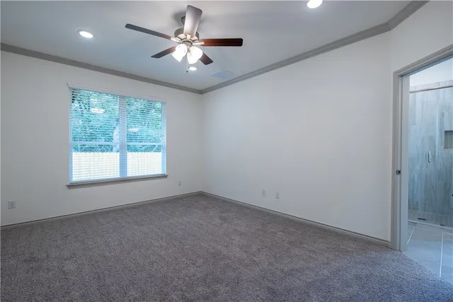 an empty room with chandelier fan and windows