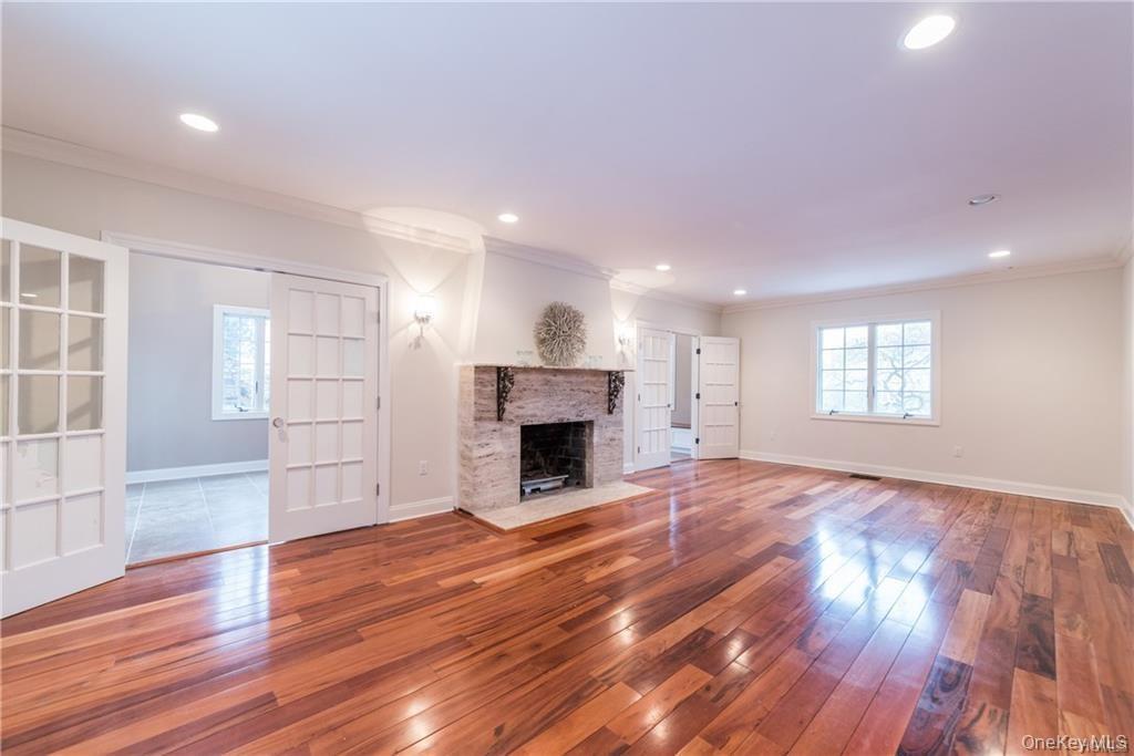 1 Elizabeth Road New Rochelle, NY 10804 - Photo 8 of 23 Unfurnished living room with ornamental molding, wood-type flooring, baseboards, a fireplace with flush hearth, and recessed lighting
