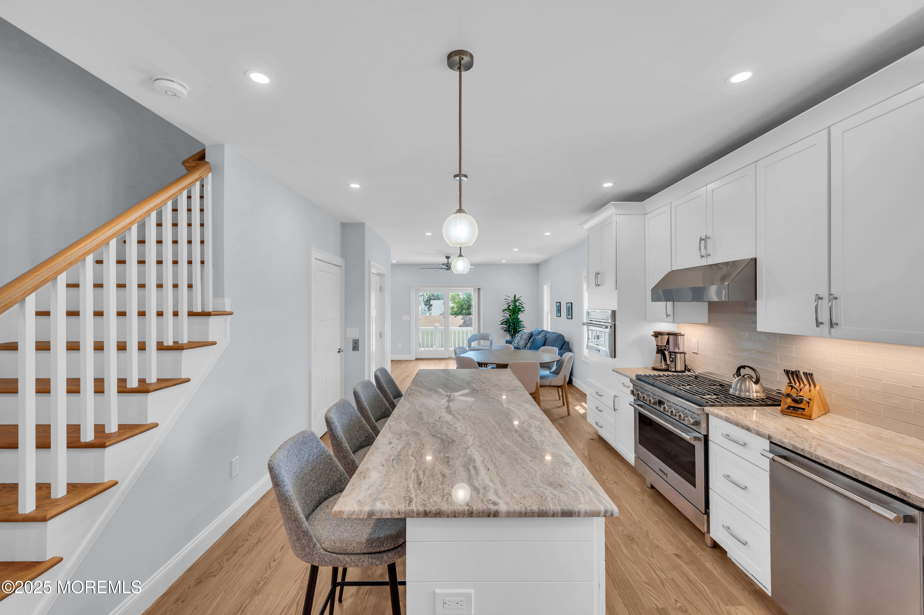 1503 Grand Central Avenue, Unit 2 Lavallette, NJ 08735 - Photo 20 of 47 a kitchen with granite countertop kitchen island stainless steel appliances a stove a sink a refrigerator a center island a dining table and chairs