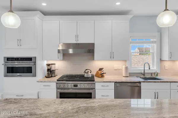 a kitchen with stainless steel appliances granite countertop a stove and a sink
