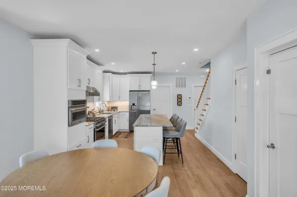 a living room with furniture a wooden floor and a kitchen view