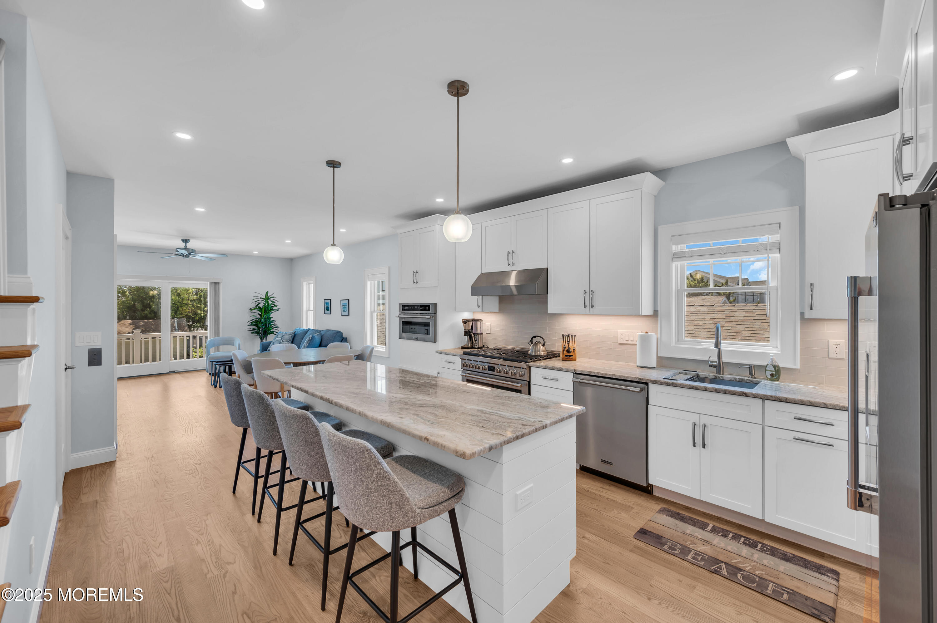 1503 Grand Central Avenue, Unit 2 Lavallette, NJ 08735 - Photo 23 of 47 a kitchen with stainless steel appliances kitchen island granite countertop a stove a sink a refrigerator a center island and a wooden floor