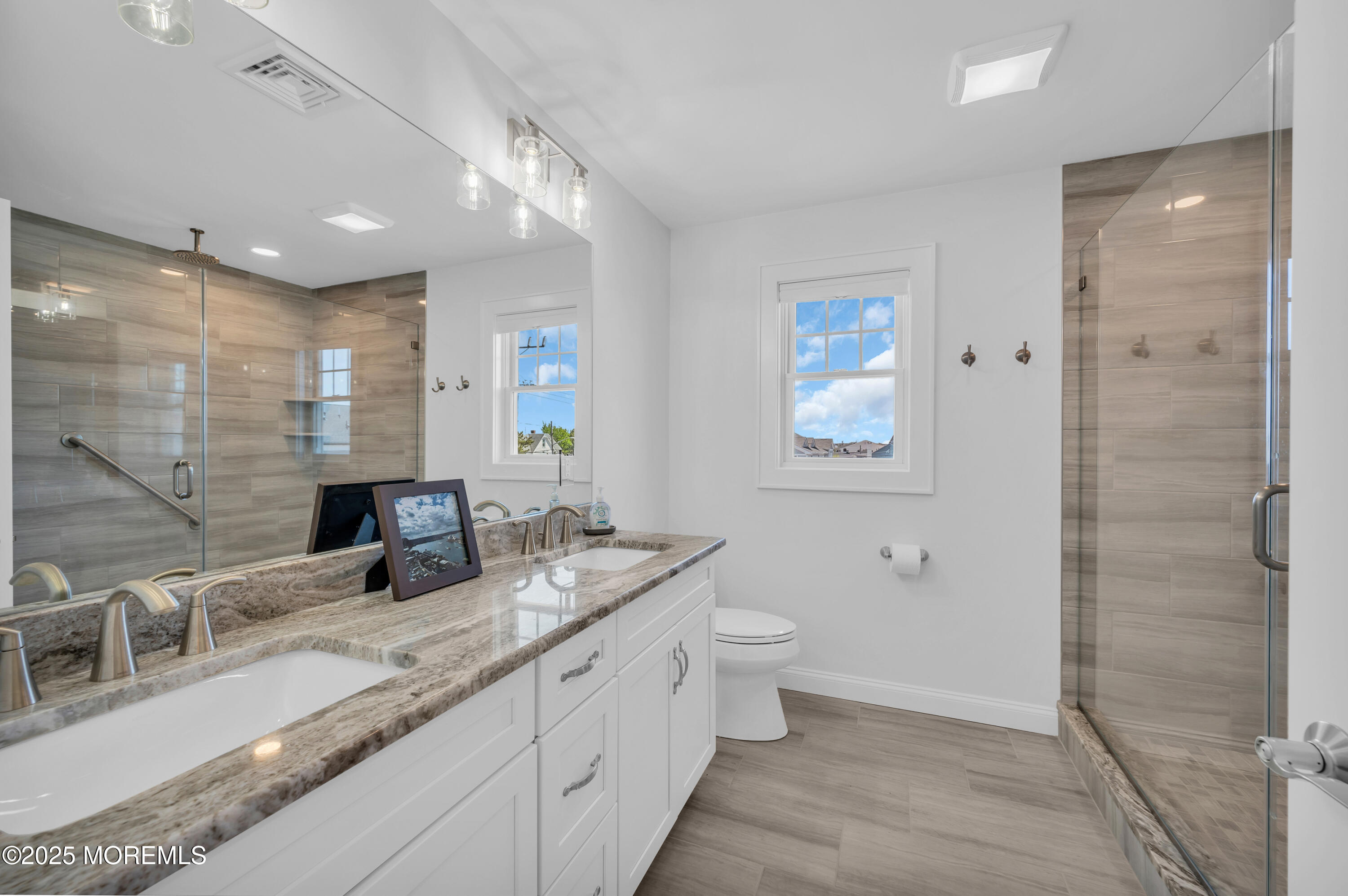 1503 Grand Central Avenue, Unit 2 Lavallette, NJ 08735 - Photo 29 of 47 a bathroom with double vanity sinks a toilet a mirror and shower