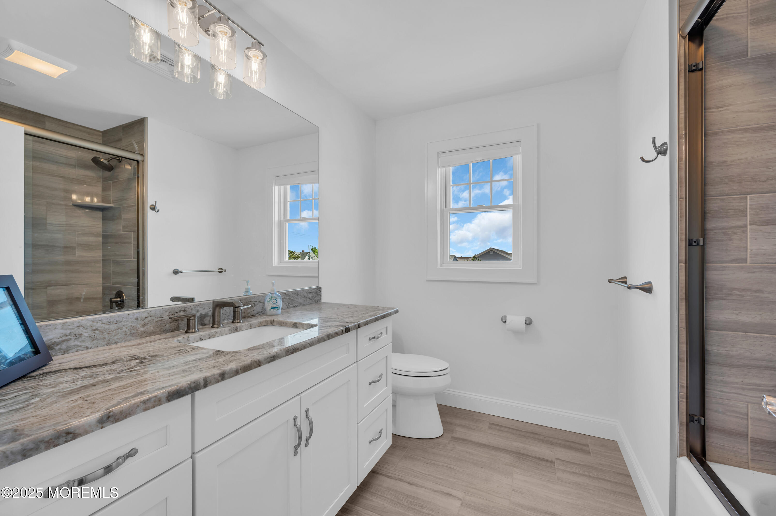 1503 Grand Central Avenue, Unit 2 Lavallette, NJ 08735 - Photo 32 of 47 a bathroom with a granite countertop toilet a sink and a mirror