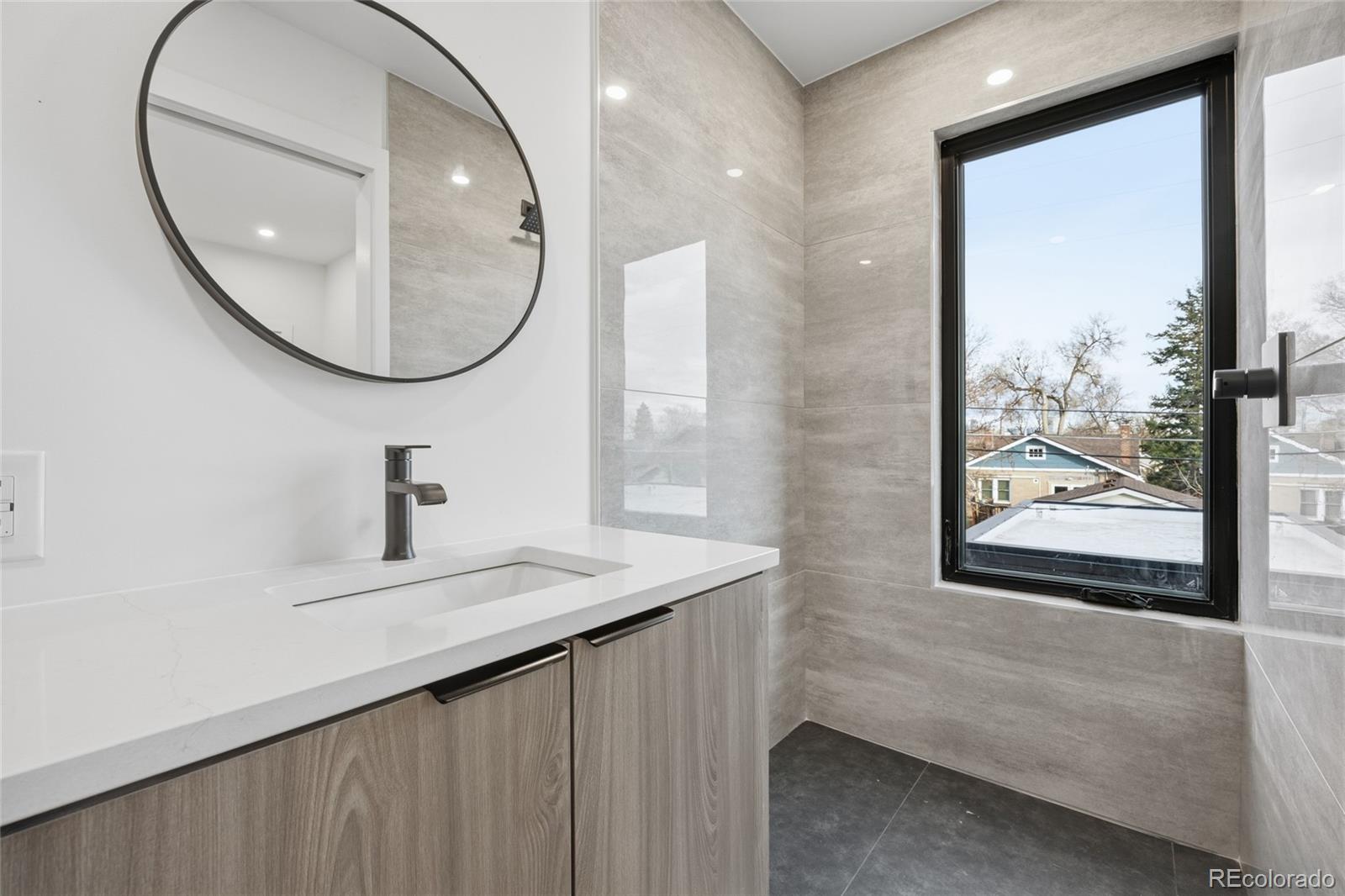 1448 Stuart Street Denver, CO 80204 - Photo 17 of 27 a bathroom with a sink and a mirror