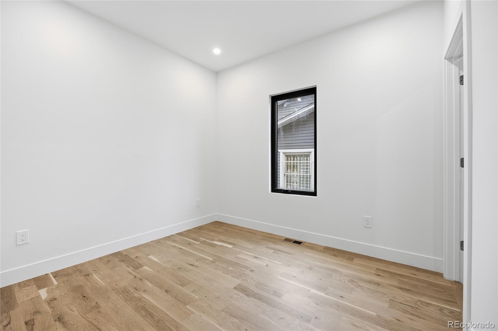1448 Stuart Street Denver, CO 80204 - Photo 20 of 27 an empty room with wooden floor and windows