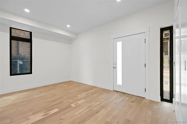 a view of an empty room with a kitchen and entryway