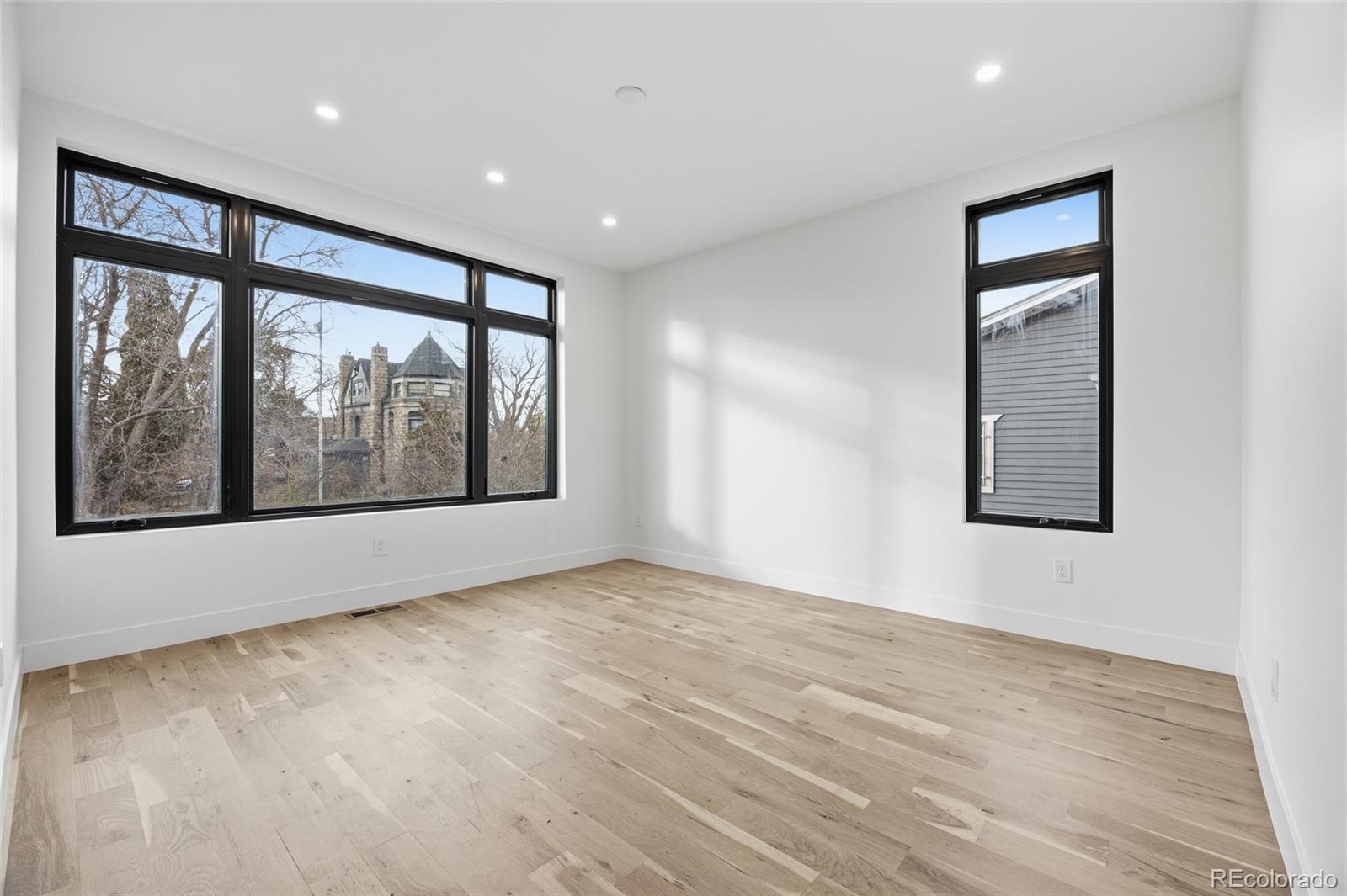 1448 Stuart Street Denver, CO 80204 - Photo 23 of 27 a view of an empty room with a window and wooden floor