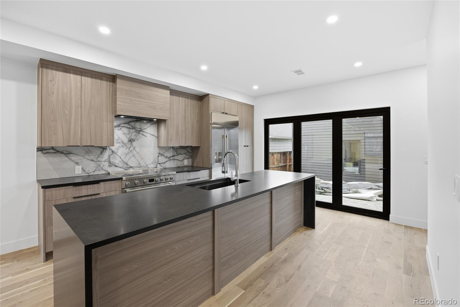 1448 Stuart Street Denver, CO 80204 - Photo 6 of 27 a large kitchen with granite countertop a stove and a sink