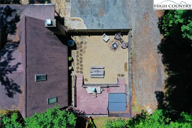 an aerial view of a house with a yard and seating space