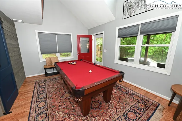 a room with pool table and windows