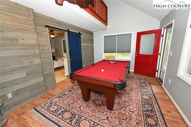 a room with pool table and windows