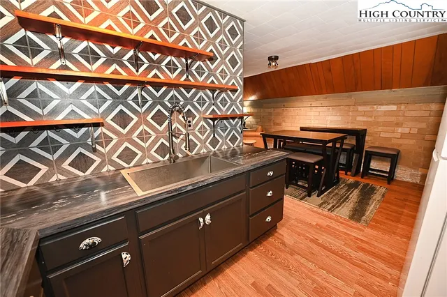 a kitchen with a sink and wooden floor