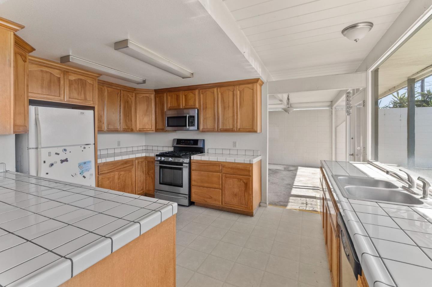 220 Mortimer Lane Marina, CA 93933 - Photo 13 of 42 a kitchen with stainless steel appliances kitchen island granite countertop a stove sink and cabinets