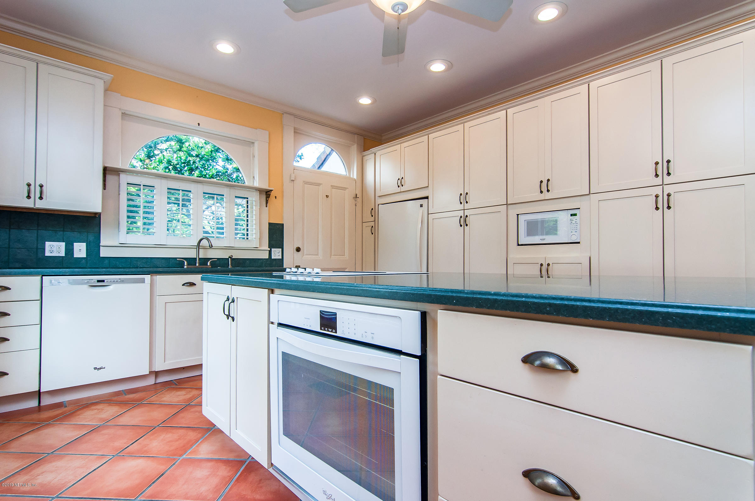 39 Valencia Street St. Augustine, FL 32084 - Photo 16 of 58 a kitchen with kitchen island granite countertop white cabinets and white appliances