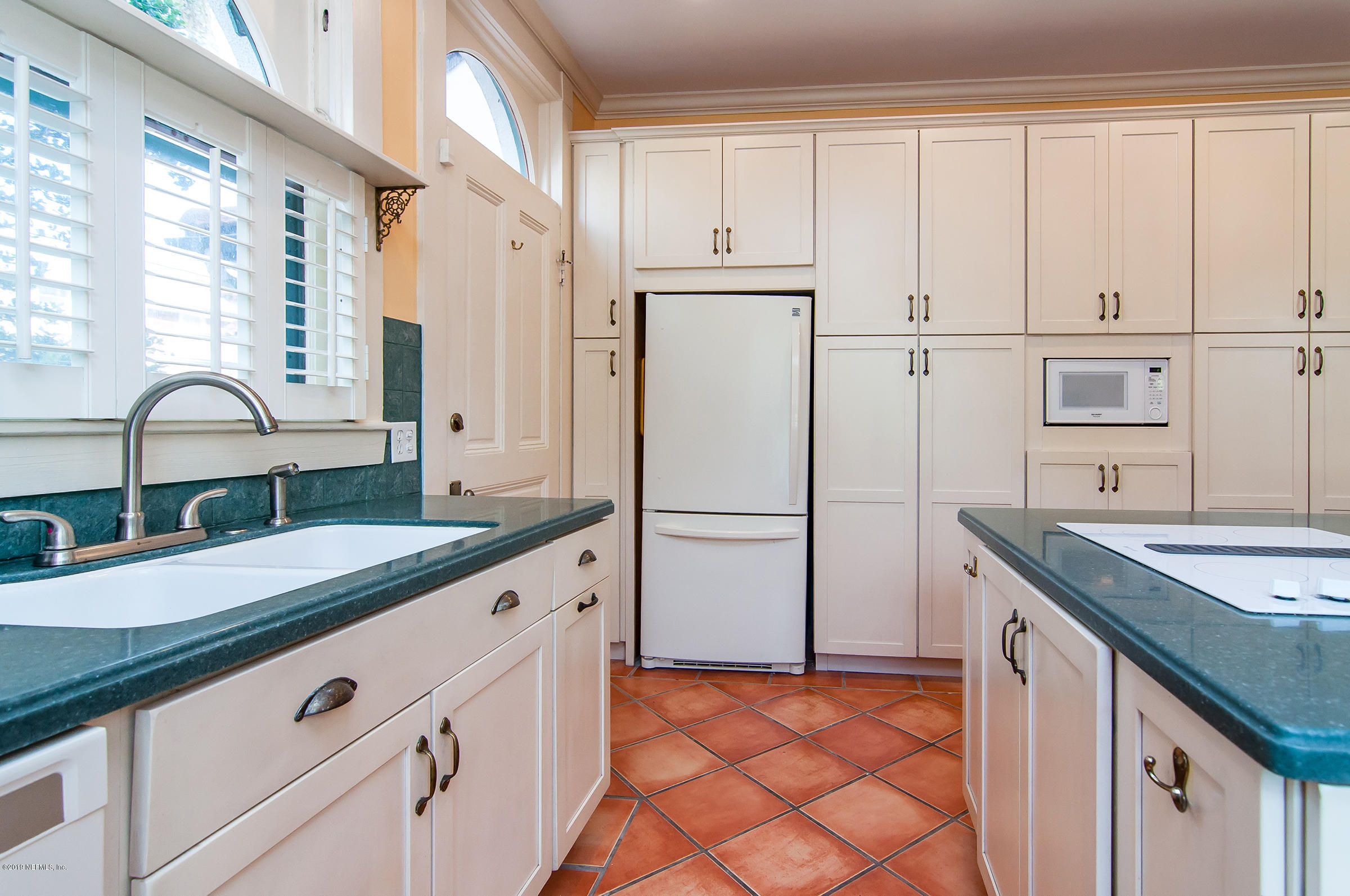39 Valencia Street St. Augustine, FL 32084 - Photo 17 of 58 a kitchen with granite countertop white cabinets and white appliances